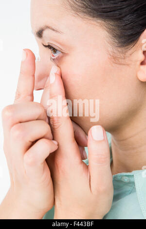 Brünette setzen ihre Kontaktlinse Stockfoto
