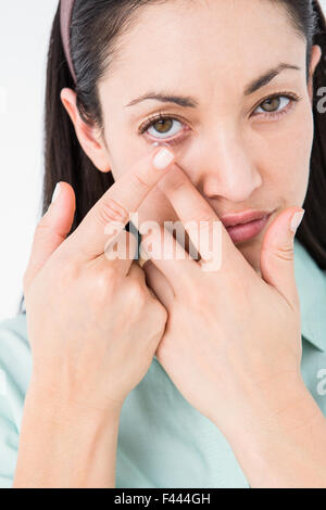 Brünette setzen ihre Kontaktlinse Stockfoto