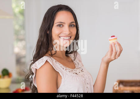 Schöne Brünette mit Mini cupcake Stockfoto