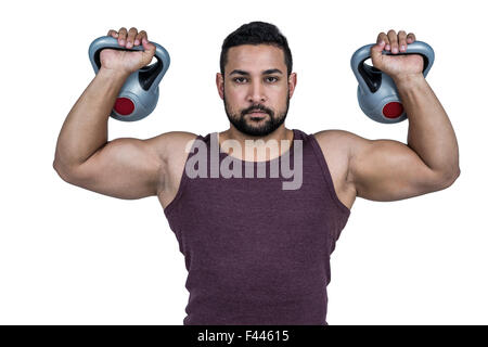 Muskuläre ernster Mann heben kettlebells Stockfoto