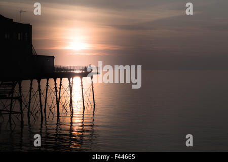 4 Personen auf Aberystwyth Pier bei Sonnenuntergang Stockfoto