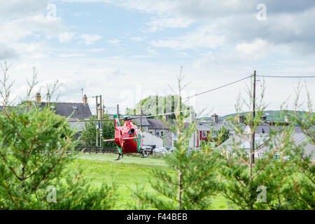 Wales-Flugrettung ausziehen nach einem Notfall, in unmittelbarer Nähe zum Strom- und Häuser fliegen Stockfoto