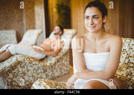 Lächelnde Frau auf einem Stuhl sitzend Stockfoto