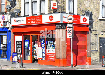 Leuchtend rotes Postbüro, Eckladen mit Geldautomaten im Freien in der Wand im Seven Kings Redbridge East London, England Stockfoto