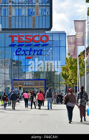 Käufer, die zu Fuß in Richtung Supermarkt Tesco Extra speichern Bestandteil der großen shopping & Wohnsiedlung in Woolwich Central South London England UK Stockfoto