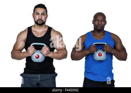 Starke Freunde heben Kettlebells zusammen Stockfoto