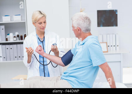 Arzt überprüft Senior mans Blutdruck Stockfoto