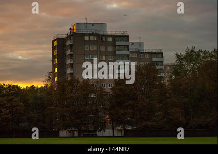 Die Sonne versinkt hinter ein 60er-Hochhaus in London Stockfoto