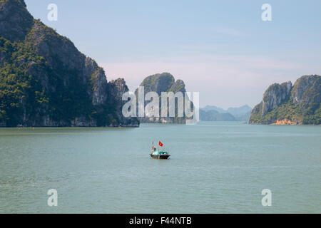 Angelboot/Fischerboot unter alten Kalksteininseln in Bai Tu long Bucht, Teil der Halong-Bucht ein UNESCO-Weltkulturerbe, Vietnam, Asien Stockfoto