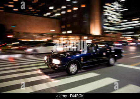 Blaues Taxi Cab mit Motion blur in der Nacht Stockfoto