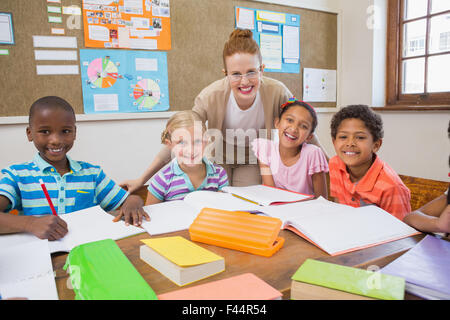 Hübsche Lehrer helfen Schülern im Klassenzimmer Stockfoto