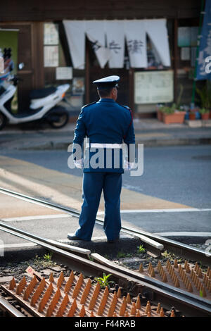 Kreuzung Wache stehend auf Schienen tragen eine blaue uniform rechts Stockfoto