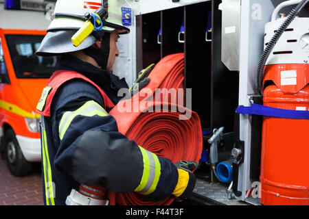 Feuerwehrmann in Aktion-Wasserschlauch Stockfoto