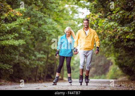 Glückliches Paar Inlineskating zusammen Stockfoto