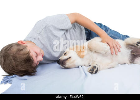 Junge liegend mit Welpen auf Decke Stockfoto