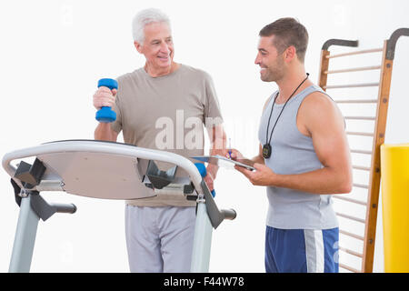 Senior woman auf Laufband mit trainer Stockfoto