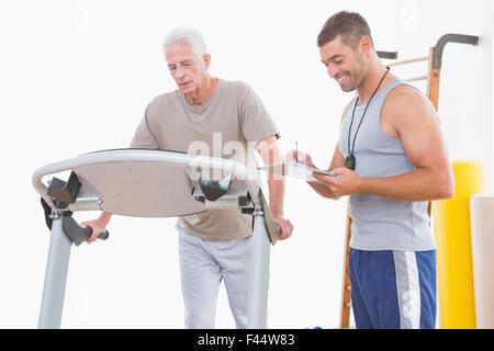 Senior woman auf Laufband mit trainer Stockfoto