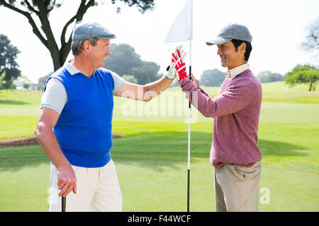 Golf Freunde hohe Fiving am Loch Stockfoto