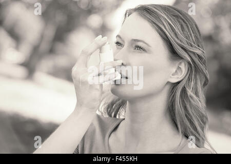 Frau mit Asthma-Inhalator im park Stockfoto