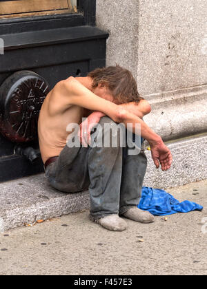 Ein unterernährt, hungrige Obdachloser schläft auf einem Bürgersteig in Cambridge, MA. Stockfoto