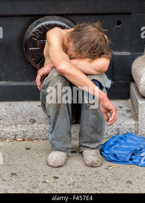 Ein unterernährt, hungrige Obdachloser schläft auf einem Bürgersteig in Cambridge, MA. Stockfoto