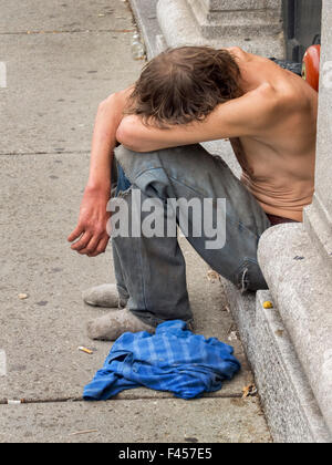 Ein unterernährt, hungrige Obdachloser schläft auf einem Bürgersteig in Cambridge, MA. Hinweis hervortretenden Knochen. Stockfoto