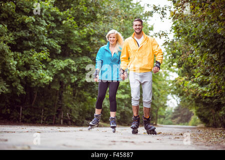 Glückliches Paar Inlineskating zusammen Stockfoto