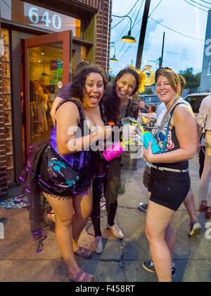 Eine spärlich bekleidete Frau, links, feiert ihren 30. Geburtstag mit Freunden an der Ecke der Frenchmen Street in New Orleans. Stockfoto
