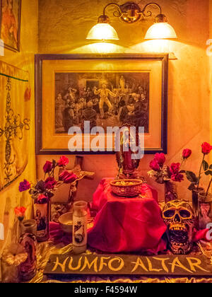 Im Voodoo Museum in New Orleans mischt sich ein Humfo Altar Christentum und Voodoo mit katholischen Heiligen, Voodoo-Geister darstellt. Hinweis: Ätzen von Voodoo-Zeremonie, Statue der Maria, künstliche Rosen und Modell Schädel. Stockfoto