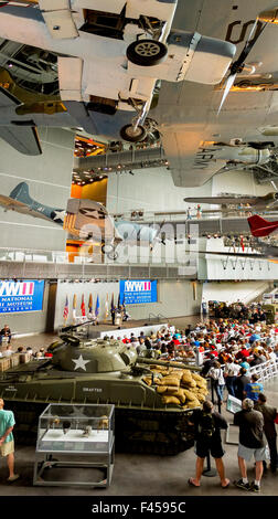 Umgeben von historischen Waffen, sammelt eine Menge für eine Einhaltung der Gedenktag an die Nation World War II Museum in New Orleans. Stockfoto