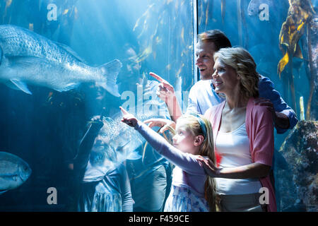 Glückliche Familie zeigt einen Fisch im tank