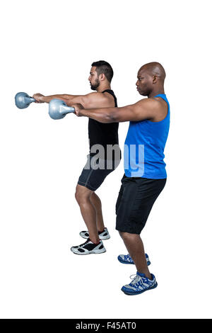 Starke Freunde heben Kettlebells zusammen Stockfoto