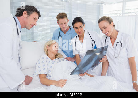 Lächelnde Ärzte zeigen Xray für Patienten Stockfoto