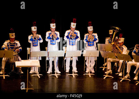 Mitglieder von einer uniformierten Blaskapelle spielen ihre Trompeten auf der Bühne bei einem Konzert der High School in Anaheim, Kalifornien. Stockfoto