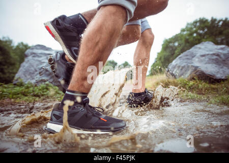 Männer gehen in schlammigen Pfützen Stockfoto