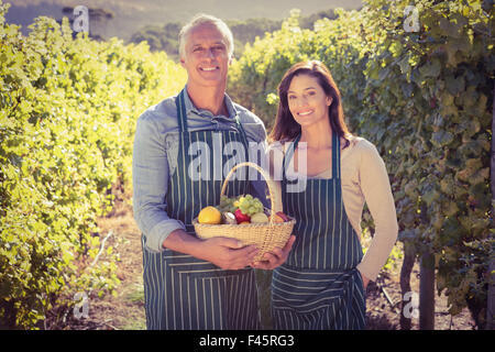 Lächelnde paar Holding Korb mit Früchten Stockfoto