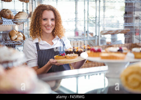 Hübsche Barista Halteplatte mit Kuchen Stockfoto