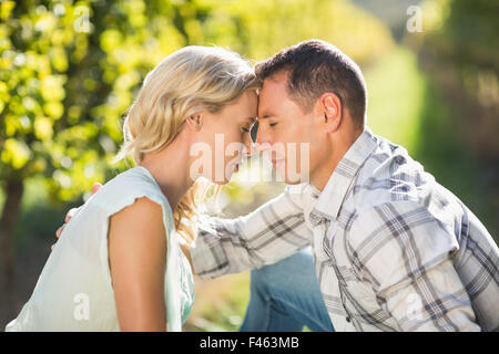 Paar sitzt eng mit Augen geschlossen neben Weinrebe Stockfoto