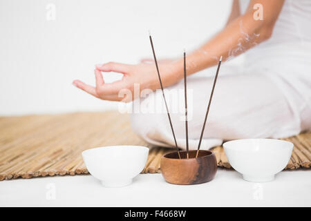 Fit Woman meditieren auf Bambusmatte Stockfoto