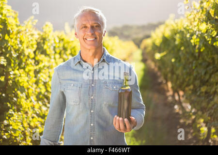 Lächelnd hält Flasche Wein Winzer Stockfoto