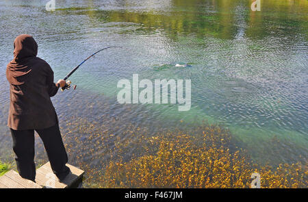 Verschleierte Frau Angeln am See Garten Stockfoto