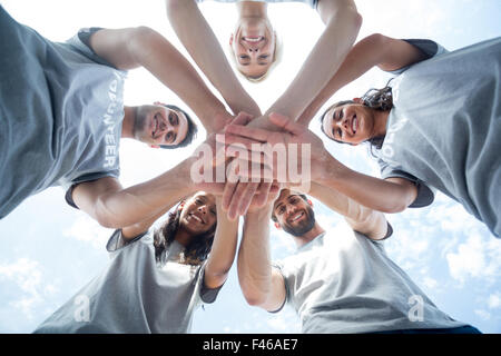 Glücklich Freiwilligen setzen Sie ihre Hände zusammen Stockfoto