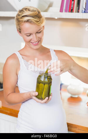 Eine schwangere Frau, die Gurken zu essen Stockfoto