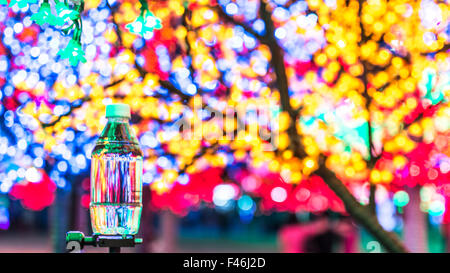 Kleine Plastikflasche Wasser mit Bokeh Hintergrund Stockfoto