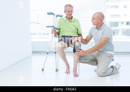 Arzt untersucht seinen Patienten Knien Stockfoto