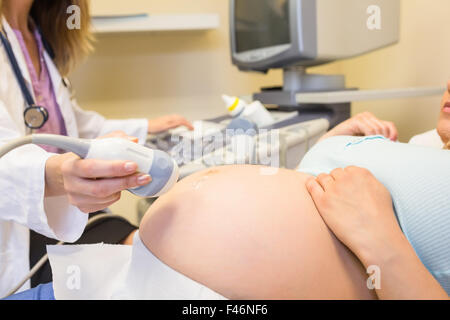 Herr Doktor Scan schwangeren Patientin Bauch Stockfoto