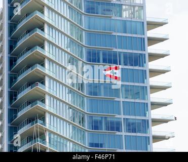 Ein Blick auf den Beirut Marina Tower in Zaitunay Bay im Libanon und die libanesische Flagge. Eine sehr moderne und neue Konstruktion in Zaitun Stockfoto