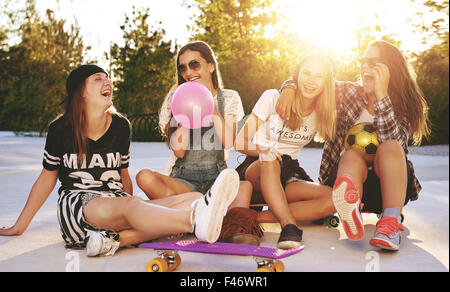 Freunde, die Spaß in einem Park mit Skateboards und Sonnenbrillen Stockfoto