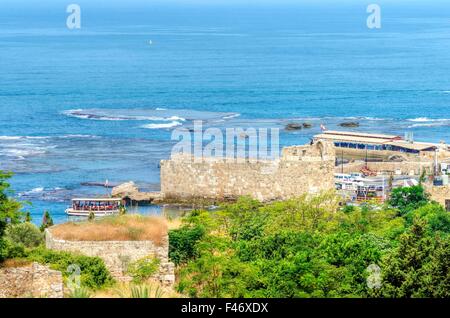 Der historische Hafen von Byblos im Libanon. Ein Blick auf den alten Mauern rund um es und ein Boot in den Hafen von Stockfoto