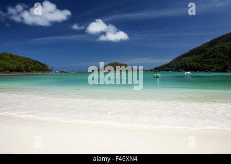 Schönen weißen Sandstrand, türkisfarbenes Meer, Boote liegen am Strand von Port Launay, Port Launay Marine Nationalpark, Insel Mahe Stockfoto